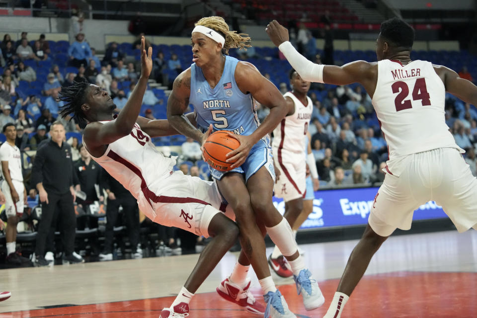 North Carolina forward Armando Bacot (5) fouls Alabama center Charles Bediako (14) on a drive to the basket during the first half of an NCAA college basketball game in the Phil Knight Invitational on Sunday, Nov. 27, 2022, in Portland, Ore. (AP Photo/Rick Bowmer)