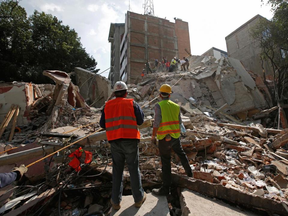 Rescue workers search for people under the rubble of a collapsed building after an earthquake hit Mexico City (Reuters)