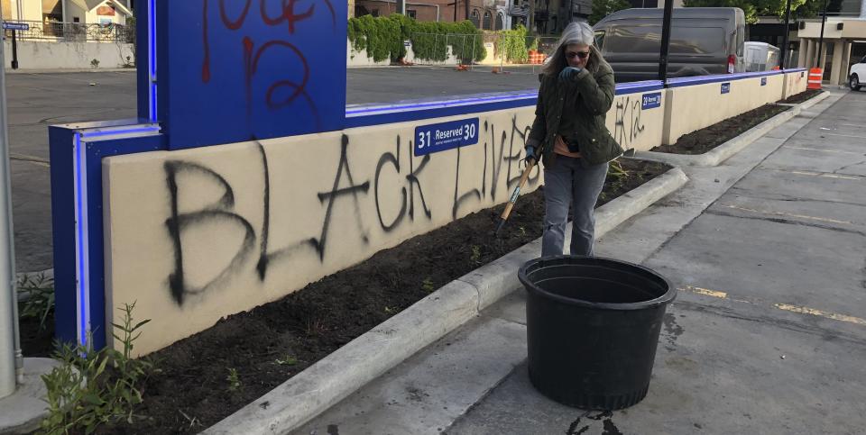 Joan Nicolai, the gardener at Gate City Bank in downtown Fargo, North Dakota, pauses to catch her breath during an early morning cleanup on Sunday. (Photo: ASSOCIATED PRESS)