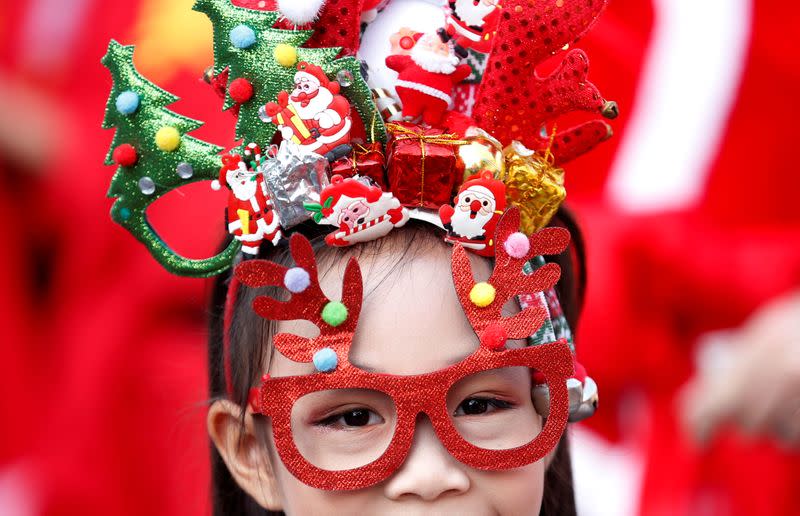 A student waits as a troupe of elephants distribute Christmas presents to students in a school in Ayutthaya