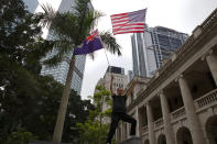 A man waves U.S. and the Hong Kong colonial flags ahead of a rally demanding electoral democracy and call for boycott of the Chinese Communist Party and all businesses seen to support it in Hong Kong, Sunday, Jan. 19, 2020. Hong Kong has been wracked by often violent anti-government protests since June, although they have diminished considerably in scale following a landslide win by opposition candidates in races for district councilors late last year. (AP Photo/Ng Han Guan)