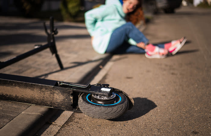 Mujer que se cae en patinete