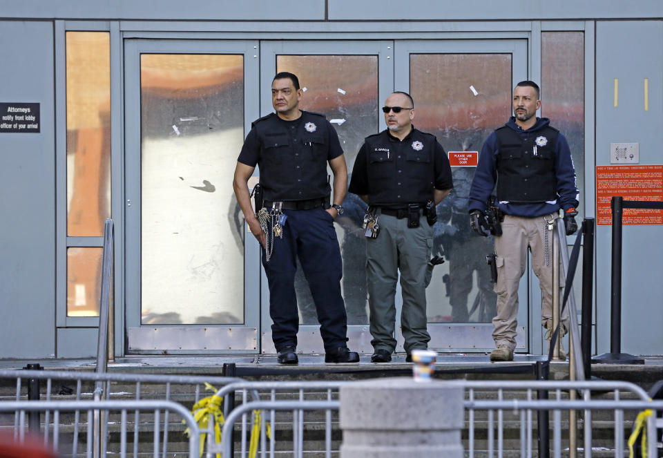 Authorities stand guard on the front steps of the Metropolitan Detention Center after dozens of family members, protesters and activists stormed the main entrance, Sunday, Feb. 3, 2019, in the Brooklyn borough of New York, as prisoners have been without heat, hot water, electricity and proper sanitation due to an electrical failure since earlier in the week. (AP Photo/Kathy Willens)