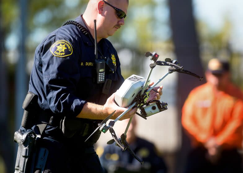 Alameda County Sheriff's Deputy Dave Durbin carries a drone while demonstrating a search and rescue operation, Friday, Aug. 14, 2015, in Dublin, Calif. As law enforcement joins the ranks of hobbyists sending drones into California skies, civil liberties advocates are raising the specter of unchecked police surveillance and state lawmakers are drafting limits. (AP Photo/Noah Berger)