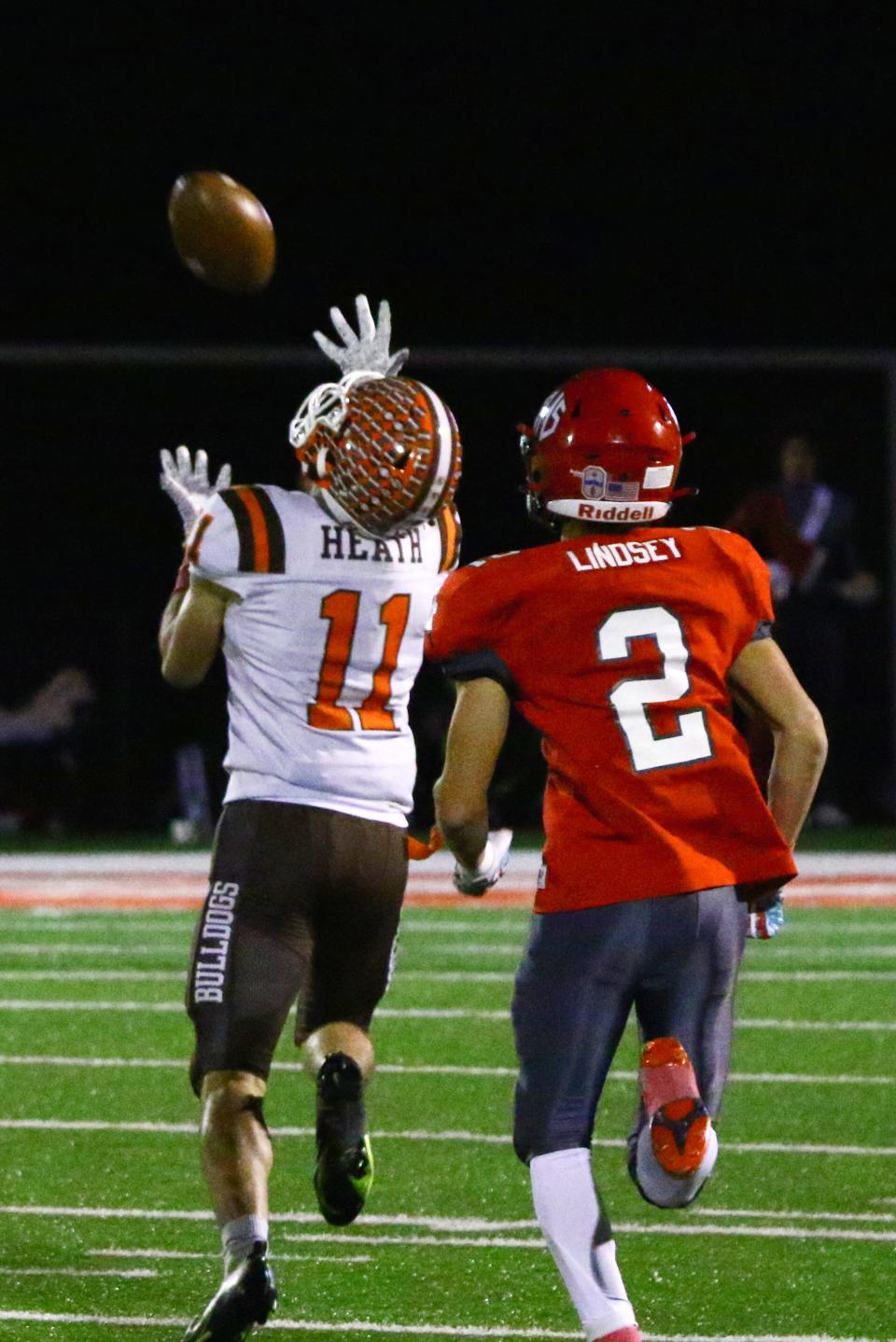 Heath junior Conner Toomey (11) hauls in a 70-yard touchdown pass from Brayden Bayles in the Bulldogs 33-24 comeback win against Johnstown last Friday at Frank H. Chambers Stadium.