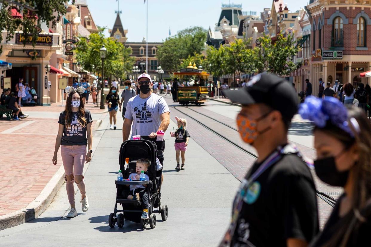 A family walking along Main Street wears masks at Disneyland Resort in Anaheim, CA.