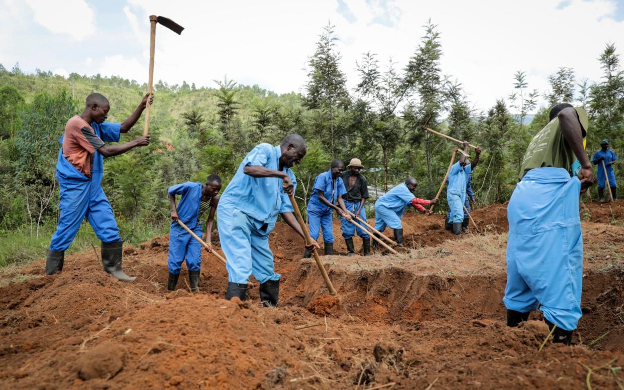 Workers with Burundi's truth and reconciliation commission dig for human remains at the site of a mass grave at Bukirasazi hill, Karusi province, Burundi Monday, Feb. 17, 2020. - AP