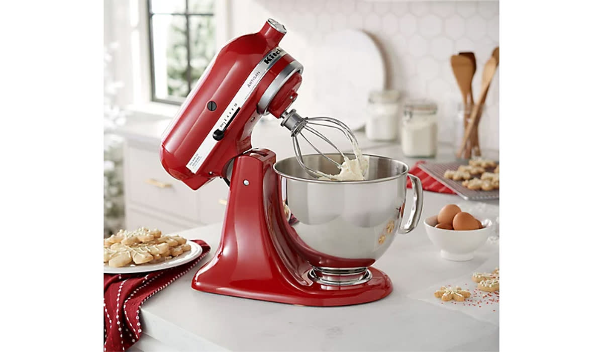 red KitchenAid mixer tilted back showing whipped cream being made in the bowl. 