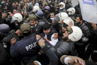 Police officers scuffle with angry lawyers during a clash in Lahore, Pakistan, Wednesday, Dec. 11, 2019. Hundreds of Pakistani lawyers, angered over alleged misbehavior of some doctors toward one of their colleagues last month, stormed a cardiology hospital in the eastern city of Lahore, setting off scuffles with the facility's staff and guards that left heart patients unattended for several hours. (AP Photo/K.M. Chaudary)