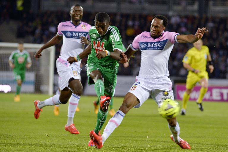 Saint-Etienne's Max-Alain Gradel (C) shoots to score between Evian's Cedric Mongongu (L) and Kassim Abdallah during their French L1 match at the Parc des Sports stadium in Annecy, on May 16, 2015