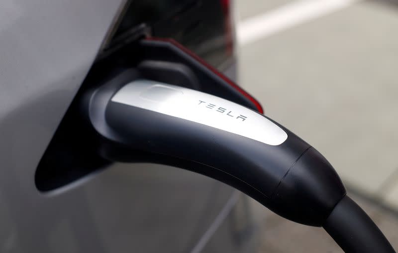 FILE PHOTO: A Tesla car is charged at a super-fast multi-charging power column in Bonn