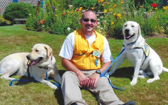 Leland Russell Jr. with two dogs in the training program at WCC. (Photo: Courtesy of Chris Blackwell)