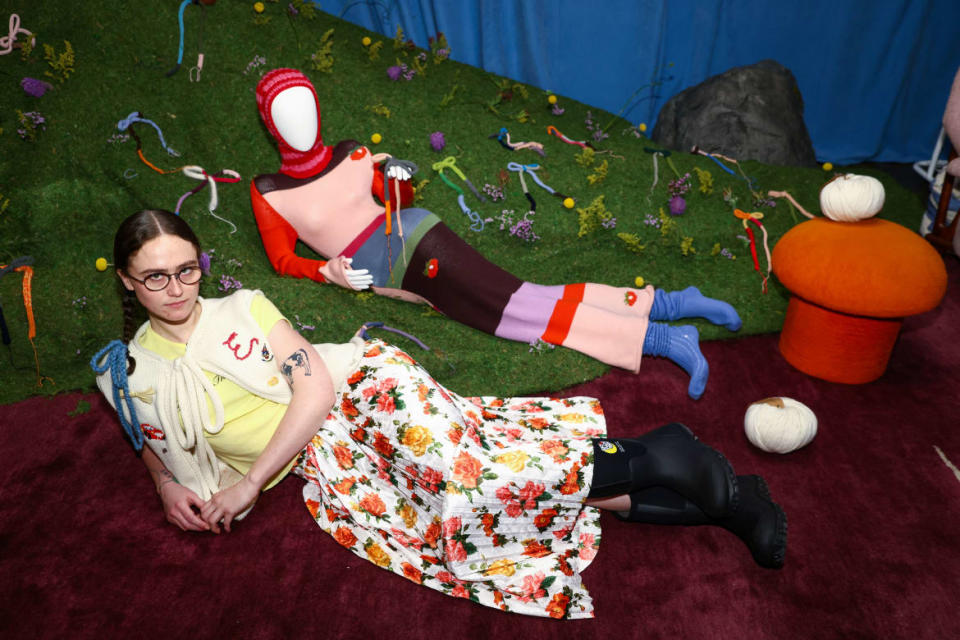 Ella Emhoff poses during New York Fashion Week by lying on the floor in an artistic dress.