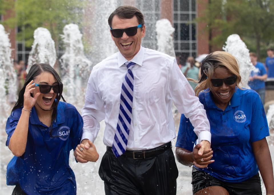 From left to right, Student Government President Atlantica Smith, University of Memphis President Bill Hardgrave and Student Government Vice President Ansley Ecker run through the campus fountain Monday, Aug. 22, 2022, at the University of Memphis. 