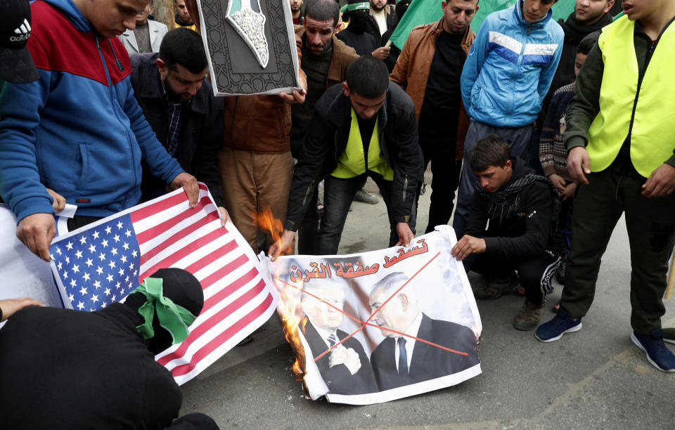 Hamas supporters burn a poster with a picture of U.S. President Trump and Israeli Prime Minister Benjamin Netanyahu and American flag during a protest against the Mideast plan announced by U.S. President Donald Trump, after the Friday prayer at the main road in Gaza City, Friday, Feb. 14, 2020. (AP Photo/Adel Hana)