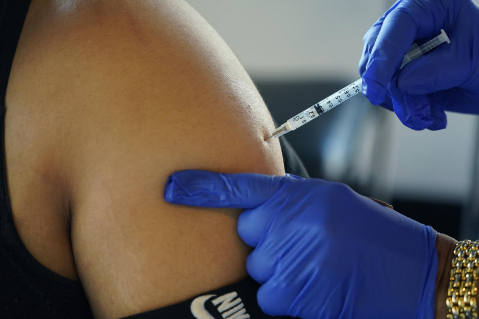 FILE - A Jackson, Miss., resident receives a Pfizer booster shot from a nurse at a vaccination site Feb. 8, 2022. On Friday, Jan. 6, 2023, The Associated Press reported on stories circulating online incorrectly claiming two researchers found that more than 1,500 athletes have suffered cardiac arrest since COVID-19 vaccinations began. (AP Photo/Rogelio V. Solis, File)