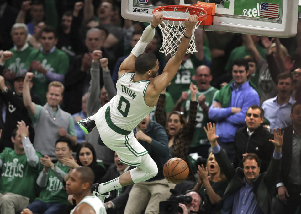 Boston Celtics forward Jayson Tatum (0) hangs on the rim after slamming a dunk against the Indiana Pacers in the final minute of the fourth quarter of Game 2 of an NBA basketball first-round playoff series, Wednesday, April 17, 2019, in Boston. The Celtics won 99-91. (AP Photo/Charles Krupa)