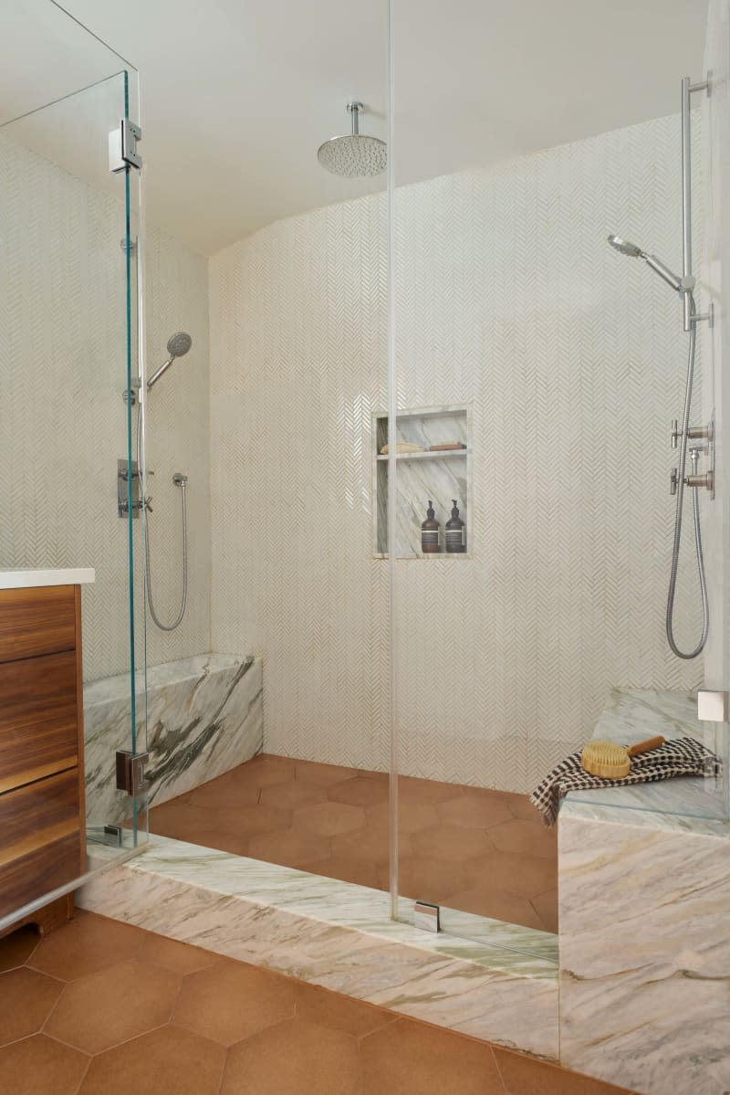 Walk in shower with glass walls and marble built in shower seat, waterfall shower head