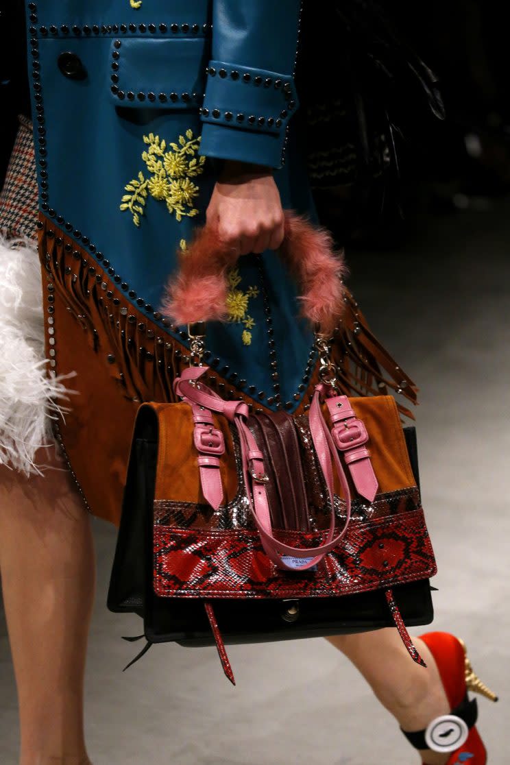 A model carries a pink fur-lined handle bag also made of suede and snakeskin at the Prada Fall/Winter 2017 show. (Photo: Getty)