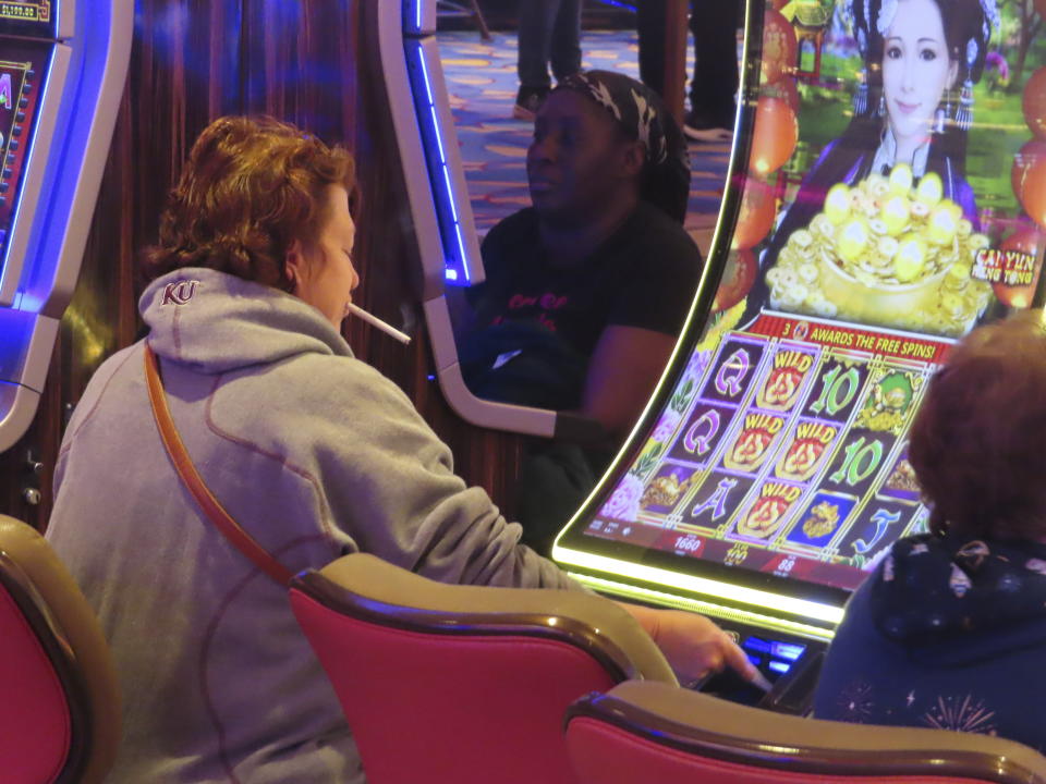 A gambler smokes while playing a slot machine at the Hard Rock casino in Atlantic City, N.J. on Feb. 2, 2024. Competing bills in the New Jersey Legislature in February 2024 would either ban smoking outright in Atlantic City's nine casinos or allow it to continue with additional restrictions. (AP Photo/Wayne Parry)