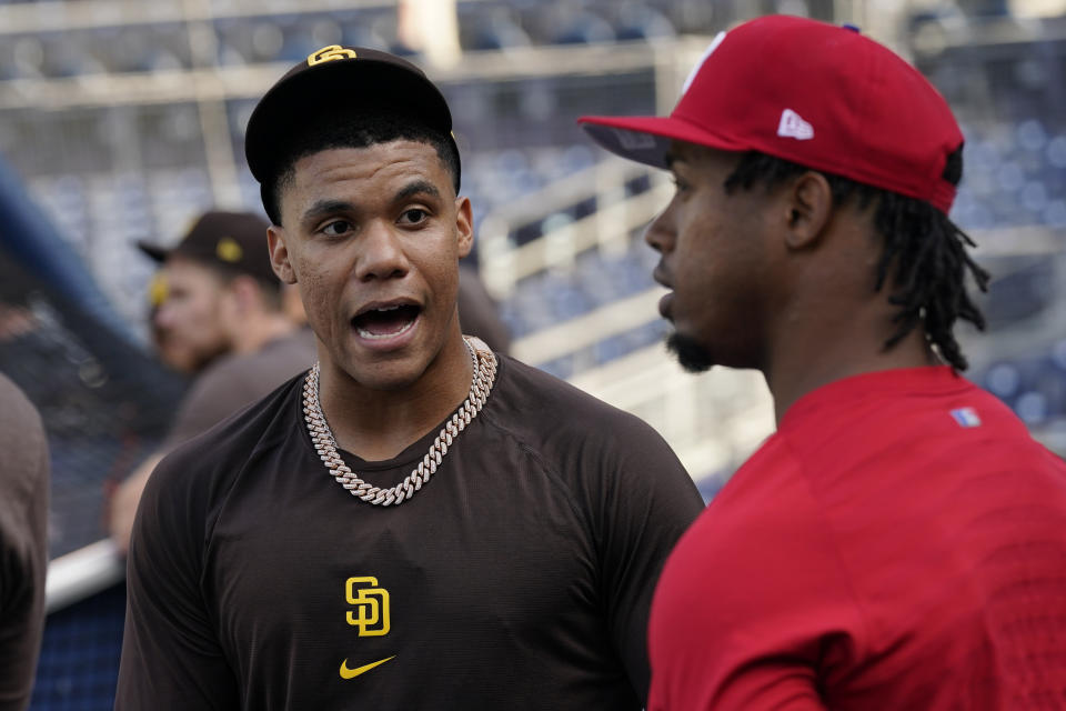San Diego Padres right fielder Juan Soto, left, talks with Philadelphia Phillies second baseman Jean Segura during practice ahead of Game 1 of the baseball NL Championship Series Monday, Oct. 17, 2022, in San Diego. The Padres host the Phillies for Game 1 Oct. 18. (AP Photo/Gregory Bull)