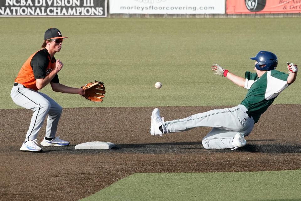 Adrian Post 275's Cole Breitenwischer (Clinton) slides into second base for a steal while Hudson Post 180's Blake Drogowski (Lenawee Christian) fields the throw from the catcher.