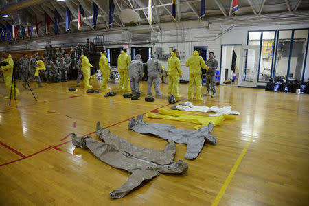 U.S. Army soldiers from the 101st Airborne Division (Air Assault), who are earmarked for the fight against Ebola, learn how to wear the protective suits before their deployment to West Africa, at Fort Campbell, Kentucky October 9, 2014. REUTERS/Harrison McClary