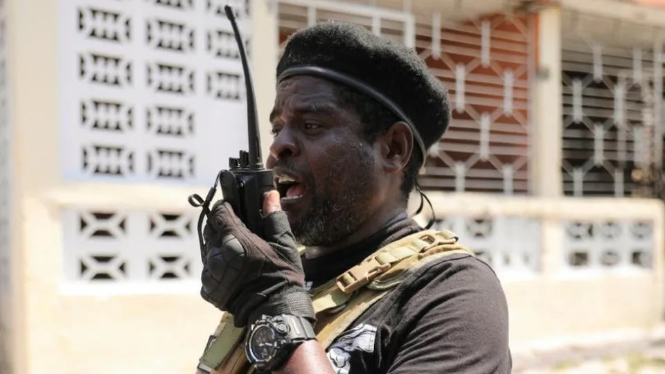 Former police officer Jimmy "Barbecue" Cherizier, and leader of an alliance of armed groups, uses a walkie talkie after addressing the media, in Port-au-Prince, Haiti, March 11, 2024.