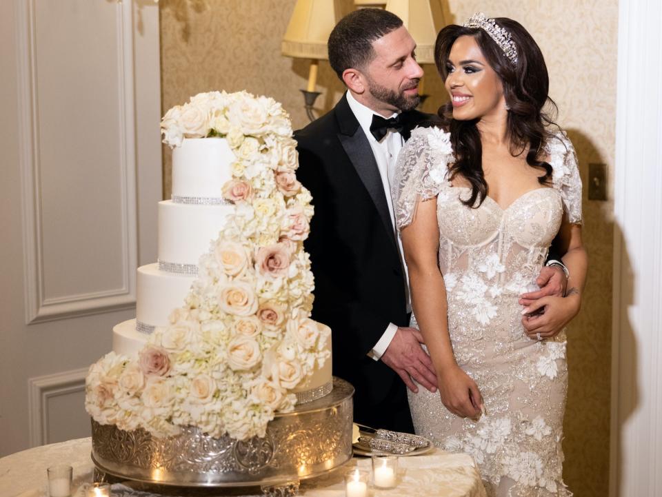 Vishnell and her husband pose next to their wedding cake