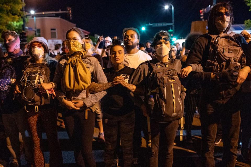 <p>Protesters lock arm as day turns night into Minneapolis. </p>