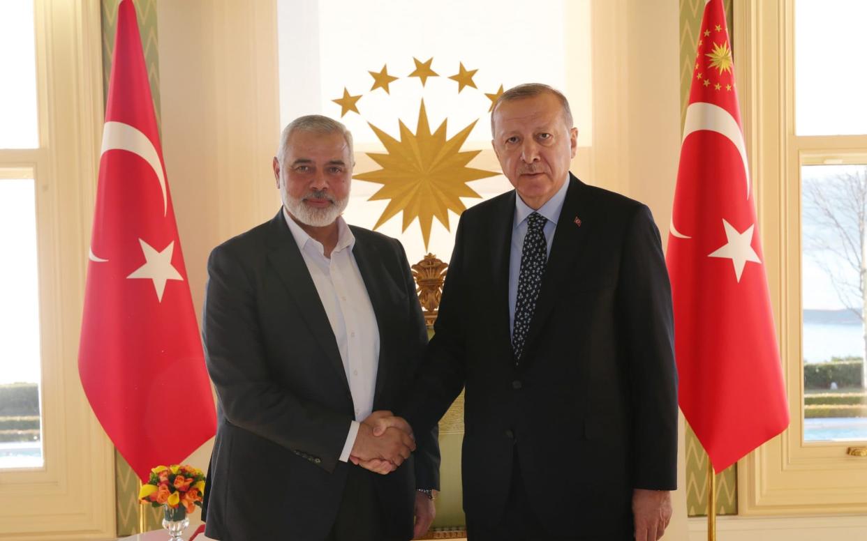 Turkish President Recep Tayyip Erdogan (R) shakes hands with Hamas political chief Ismail Haniyeh (L) - Anadolu