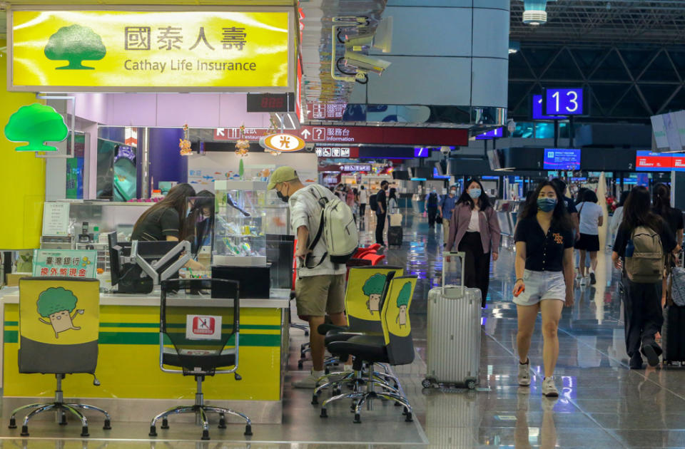 小確幸！民眾暑假想出國玩，若想要投保旅平險，保費可望便宜一成。金管會25日宣布，參酌相關經驗統計分析資料，並與保險業者、產、壽險公會、精算學會及相關周邊單位進行研商，完成檢討並調降意外死亡及失能給付標準費率表中各費率10％，7月1日正式生效。圖為桃園機場出境旅客在保險公司櫃台詢問投保相關事宜。（陳麒全攝）