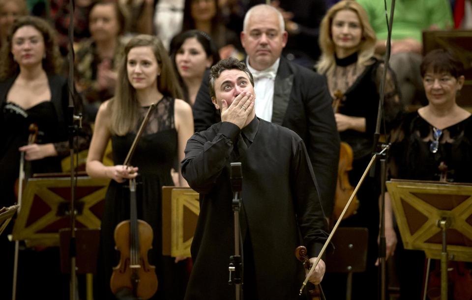 This Sept. 24, 2013 photo shows Russian-born violinist Maxim Vengerov reacting during a round of applause at the Romanian Athenaeum concert hall in Bucharest, Romania, during the George Enescu classical music festival. The festival which began in 1958 is named after Romanian composer, violinist and conductor George Enescu, who lived in Romania but moved to Paris when the communists came to power. (AP Photo/Vadim Ghirda)