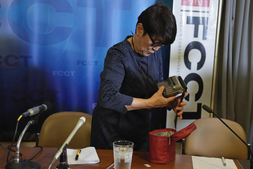 Noriko Ogawa, sister of slain Japanese journalist Kenji Nagai, puts his video camera into a case after she received its from Aye Chan Naing from Democratic Voice of Burma at the Foreign Correspondents Club in Bangkok, Thailand Wednesday, April 26, 2023. Nagai's video camera, which he had been carrying when he was shot dead covering a during a street protest in Myanmar September 2007, was missing until it was recently recovered by the Democratic Voice of Burma news service, which handed it over to his sister at the club. (AP Photo/Sakchai Lalit)