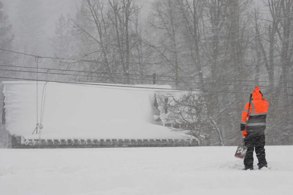 A person uses a shovel trying to clear snow from a property during a storm, Saturday, March 2, 2024, in Truckee, Calif. A powerful blizzard howled Saturday in the Sierra Nevada as the biggest storm of the season shut down a long stretch of Interstate 80 in California and gusty winds and heavy rain hit lower elevations, leaving tens of thousands of homes without power.