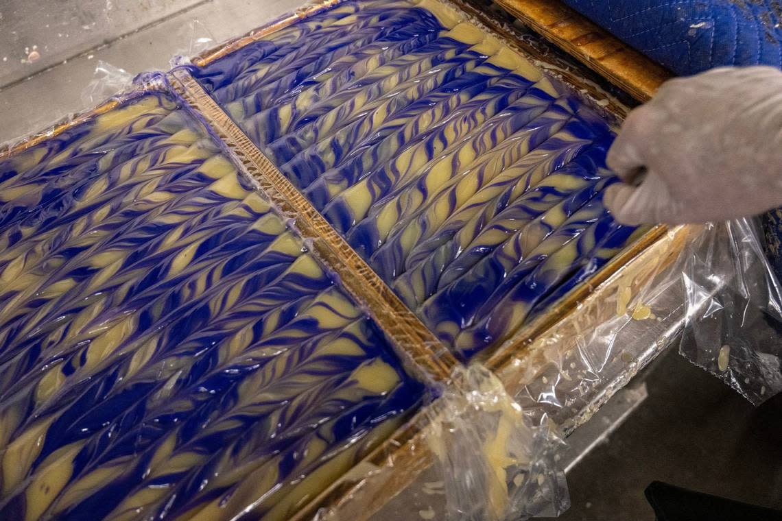 Ryan Riggs, soap maker, creates zig-zag movements to form swirls in the batch of frankincense-lavender Zum Bar soaps.