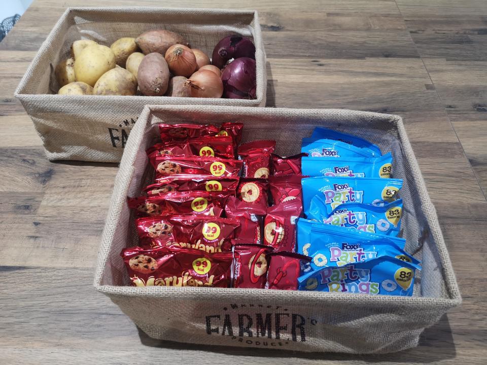 Farmer's market burlap storage boxes containing vegetables and snacks.