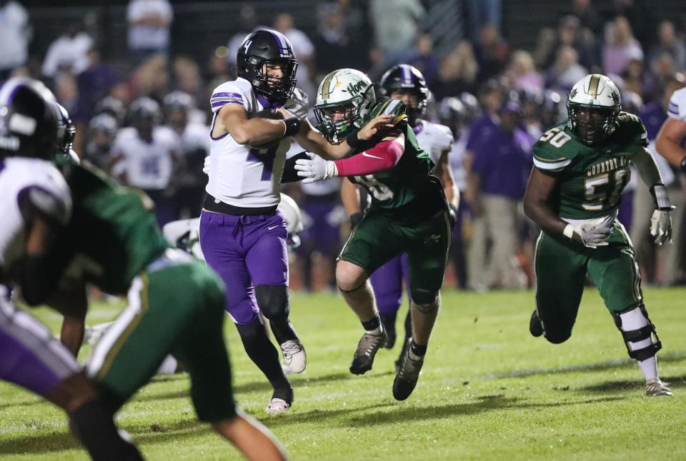 Calvary quarterback Jake Merklinger fights for yardage as Savannah Country Day's Hayes Beaver attempts to bring him down on Friday, October 20, 2023 at Savannah Country Day.