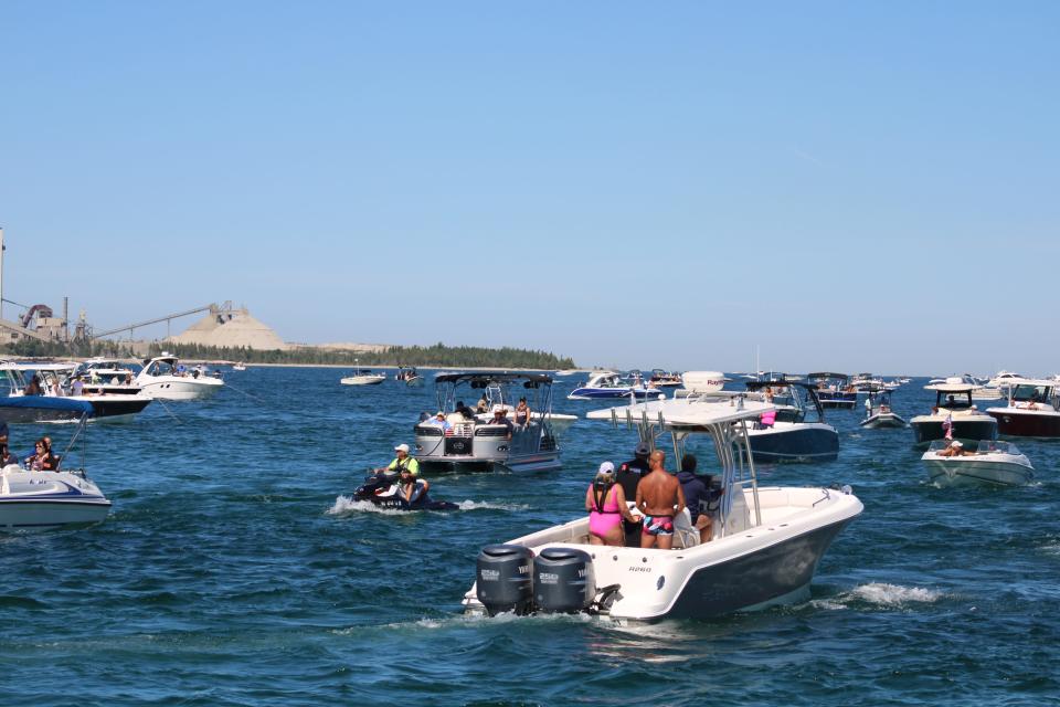 Boats crowd together at the end of Charlevoix's pier to watch the Boyne Thunder power boats speed into Lake Michigan.