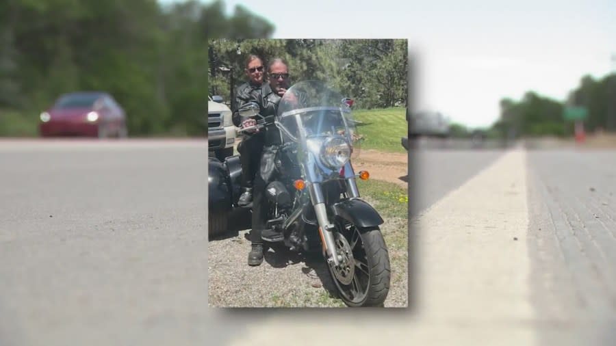 A couple sits on a Harley Davidson, overlayed ontop of a busy road.