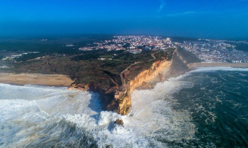 ‘Way beyond all other waves’: Nazaré’s lighthouse at Praia do Norte acts as a grandstand for spectators.