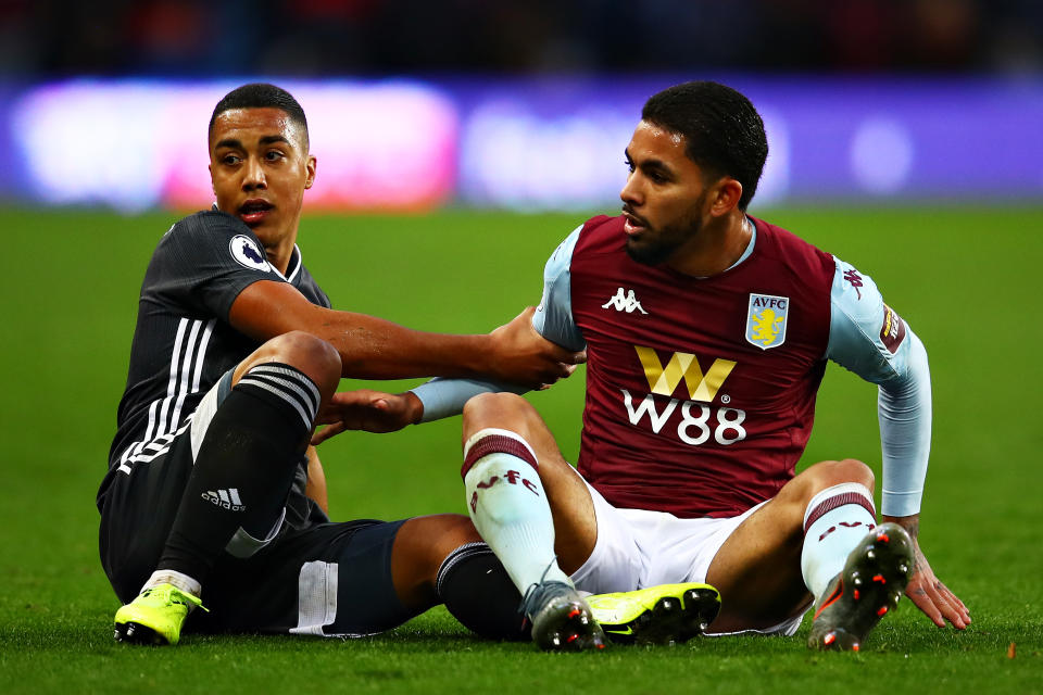 Youri Tielemans of Leicester City and Douglas Luiz of Aston Villa help each other up after a challenge  during the Premier League match between Aston Villa and Leicester City at Villa Park on December 08, 2019 in Birmingham, United Kingdom.