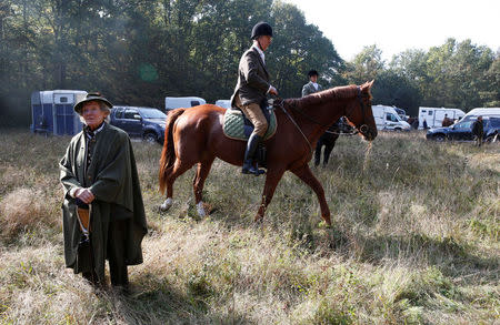 Participants wait before the start of a roe dear-hunt on horseback with hounds in the Chantilly royal estate forest, north of Paris, France, October 12, 2016. Picture taken October 12, 2016. REUTERS/Jacky Naegelen