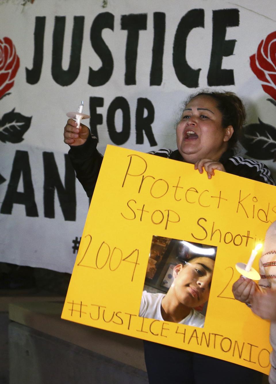 Sandra Gonzalez, mother of a slain 14-year-old boy shot by Tempe Police, joins another family members and others in front of Tempe Police headquarters to hold a protest and vigil for the boy shot to death by Tempe Police on Tuesday, as police say they were pursuing a burglary suspect who they thought had a handgun, Thursday, Jan. 17, 2019, in Tempe, Ariz. It turns out, according to police, the teen had a replica gun. (AP Photo/Ross D. Franklin)