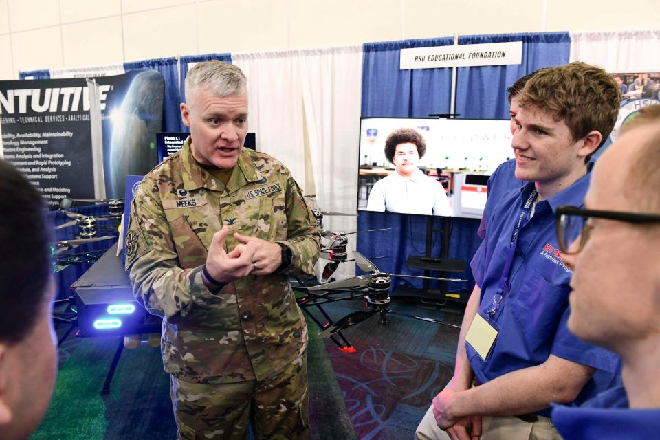 Col. Tony Meeks, commander of the Munitions Directorate at Eglin Air Force Base's Air Force Research Laboratory,  talks with students in the Hsu Educational Foundation's UAS Center of Excellence on Tuesday during the fifth annual TeCMEN Industry Day at the Destin-Fort Walton Beach Convention Center on Okaloosa Island.