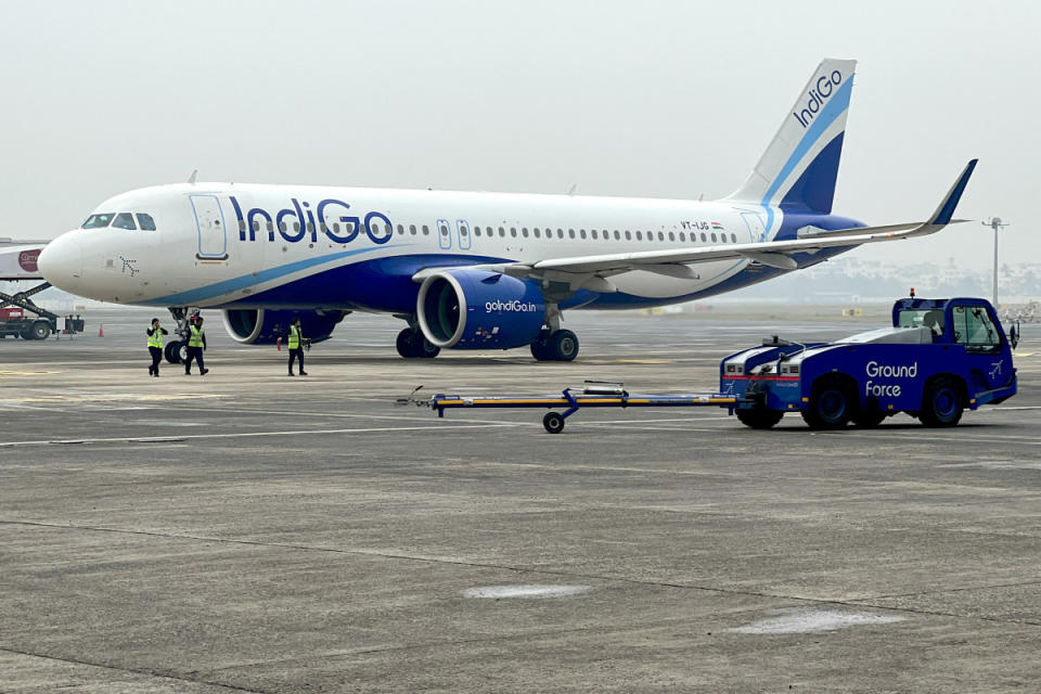 Ground staff walk past an Indigo airlines aircraft taxiing at the Netaji Subhash Chandra Bose International Airport in Kolkata. Photo by Indranil Mukherjee/AFP/Getty Images.<p>INDRANIL MUKHERJEE/Getty Images</p>