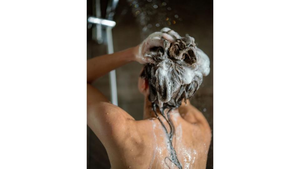 Model washing hair in shower 