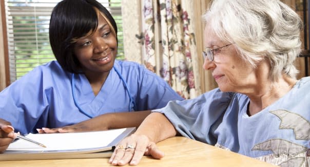 Senior woman visiting with nurse in her home