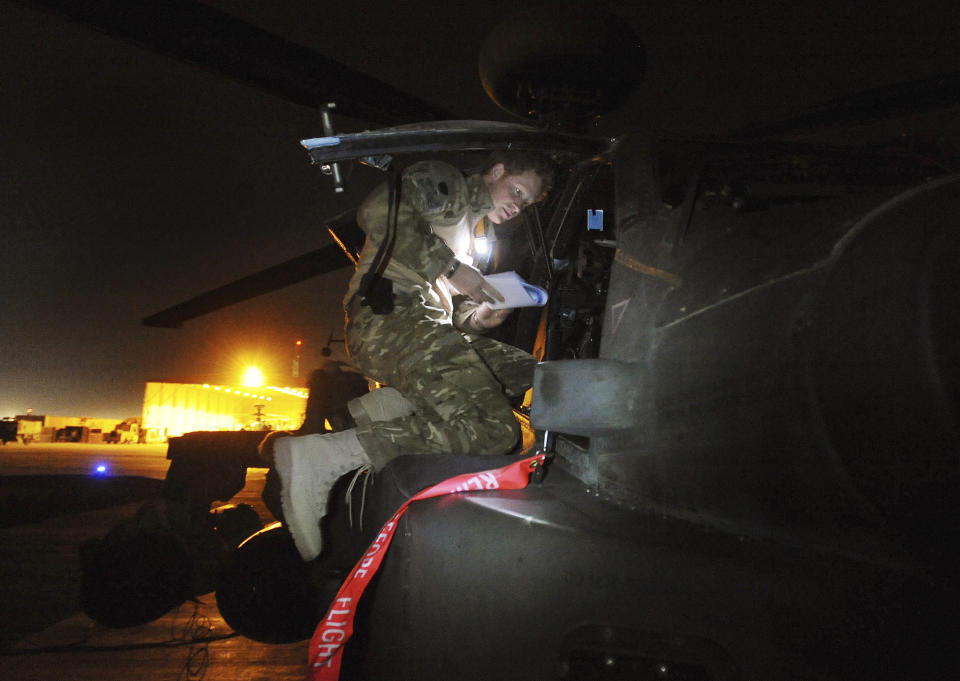 FILE- In this photo taken Dec. 11 2012, and made available Monday Jan. 21, 2013 of Britain's Prince Harry or just plain Captain Wales as he is known in the British Army, at the British controlled flight-line as he inspects his Apache Helicopter before lift off on a night mission from Camp Bastion southern Afghanistan. (AP Photo/ John Stillwell, Pool, File)