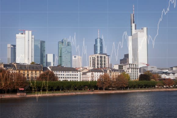 Picture of a city's skyline with a rising stock chart super-imposed in the background.